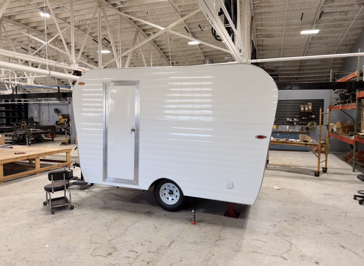White trailer shell in the shop, long side view